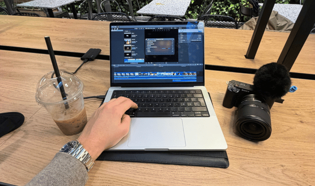 Jonathan sidder og arbejder med videoredigering på en cafe.